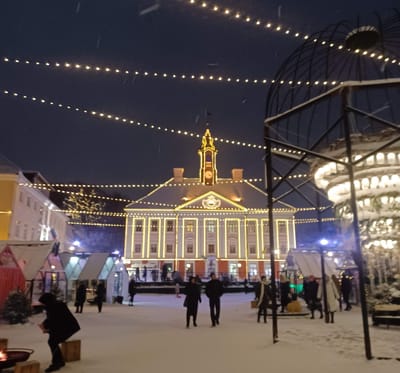 Tartu's town center lit up with festive lights, a skating rink, and a tree just out of view.