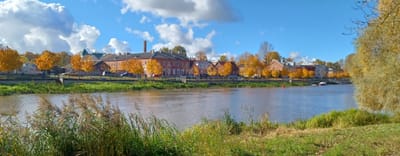 Tartu's Emajogi river under a canopy of bright autumnal trees.