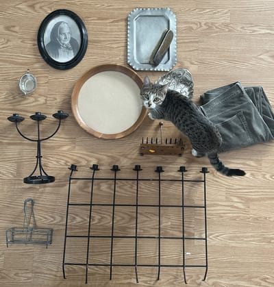 A pewter tray, silver brush, solemn portrait, frames and candlesticks laid out together